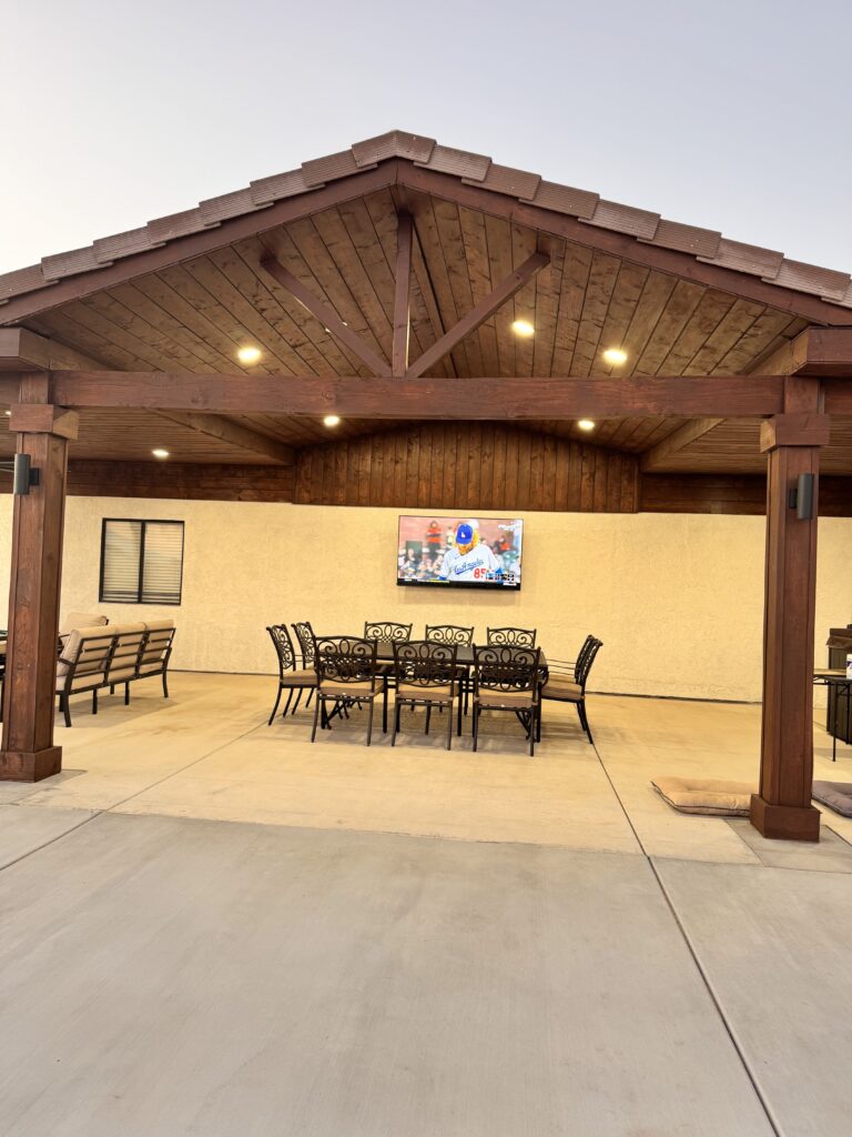Long custom aluminum patio with lights and ceiling fans. High ceiling with a western, wooden style.