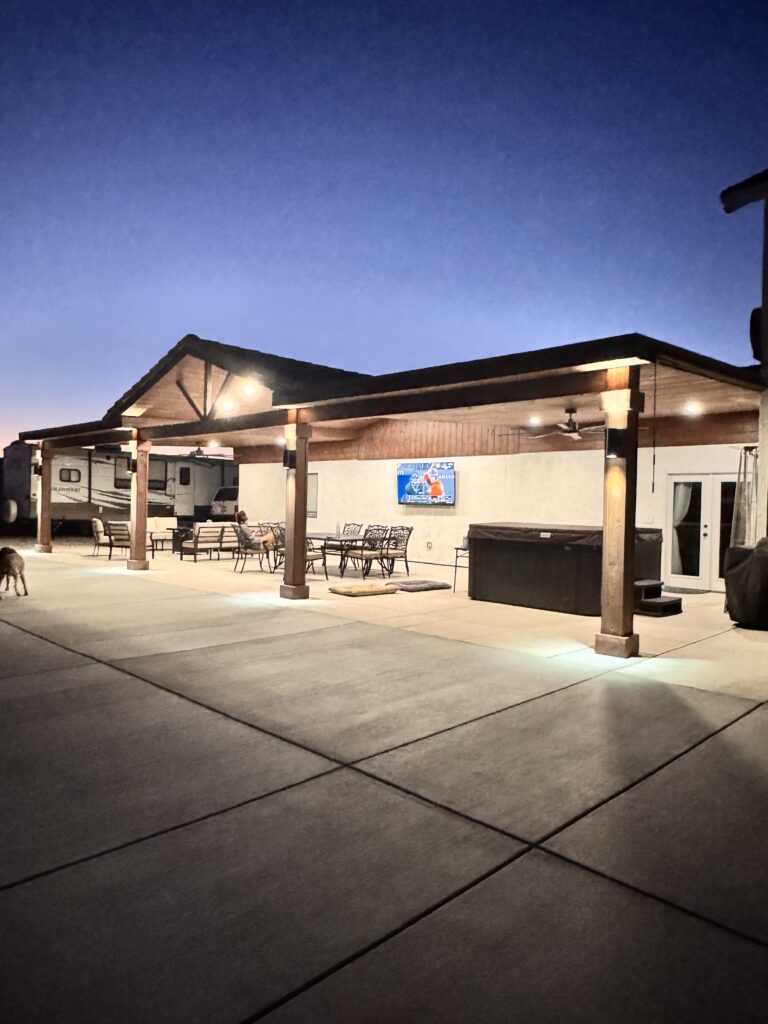 Long custom aluminum patio with lights and ceiling fans. High ceiling with a western, wooden style.